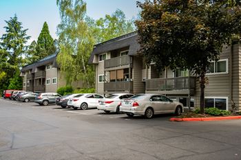 A parking lot with cars and apartment buildings in the background.